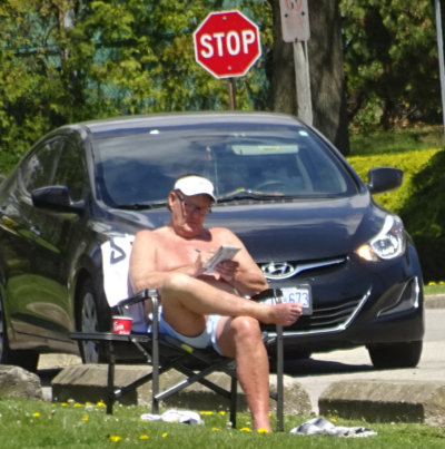LaSalle man reading in sunshine shorts